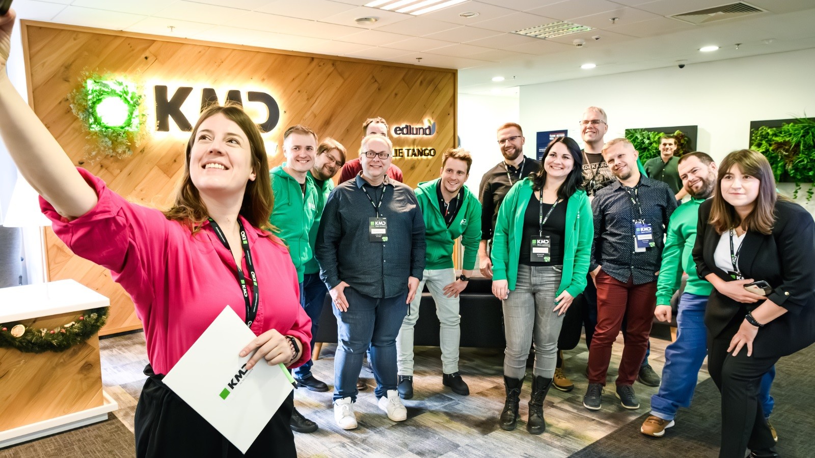KMD Poland workers in the office standing in a crowd posing for a colleague taking a selfie
