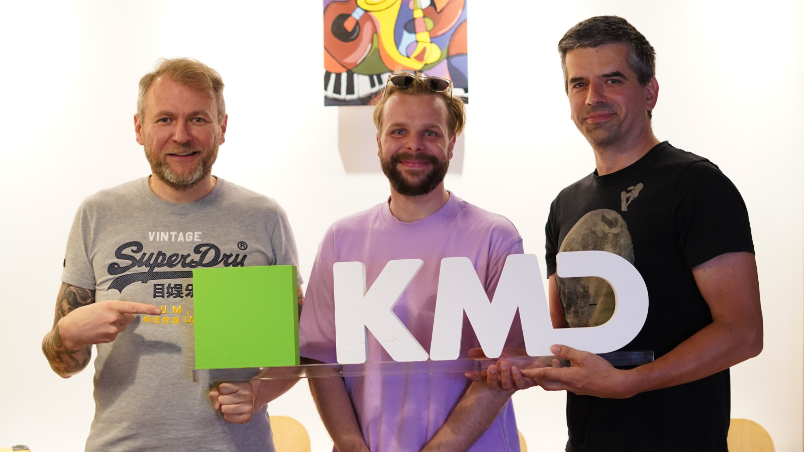 Three managers of KMD Elements team holding KMD sign