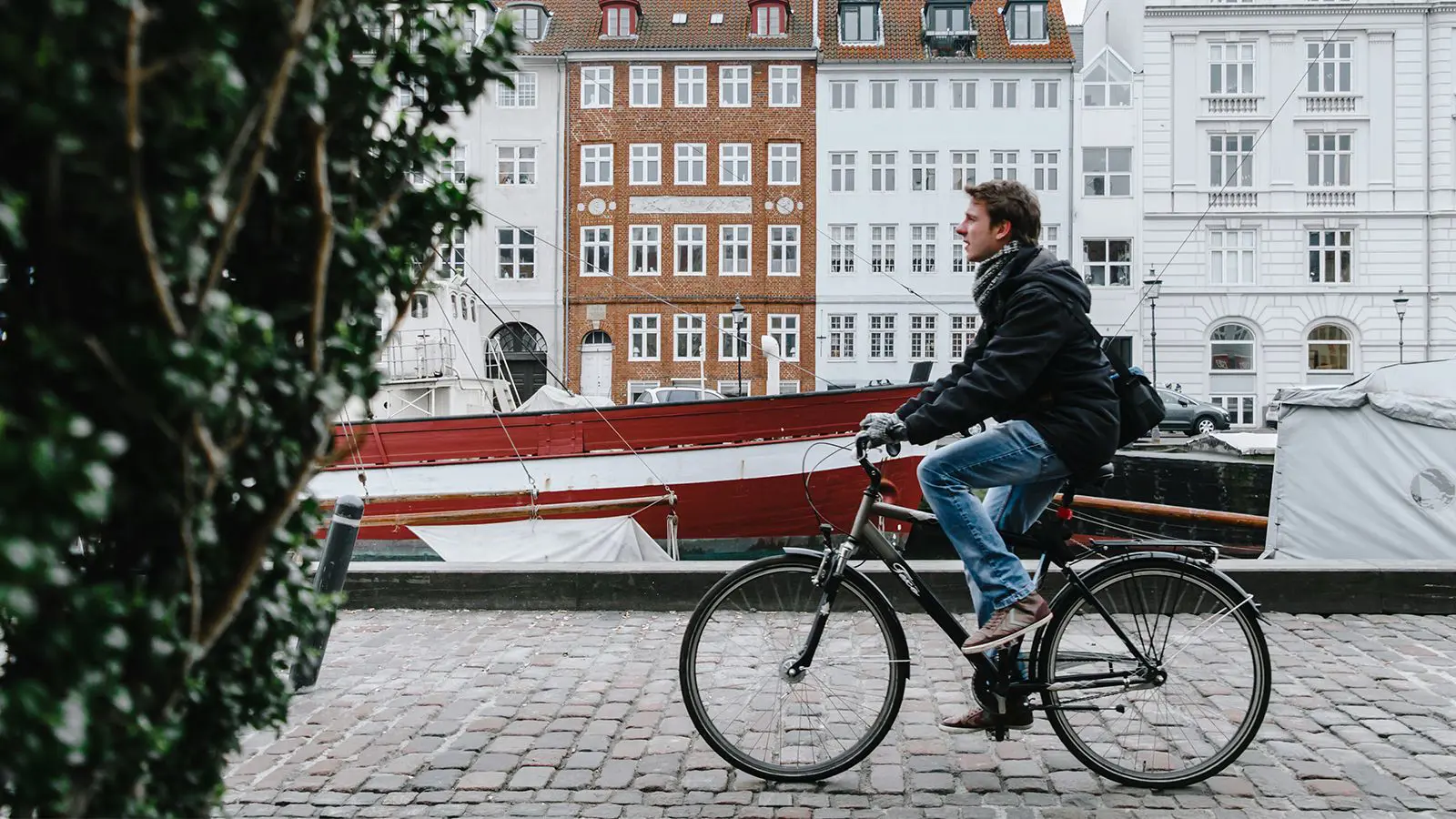 Mand som cykler gennem byen